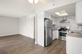 A kitchen with a refrigerator, stove, and oven.