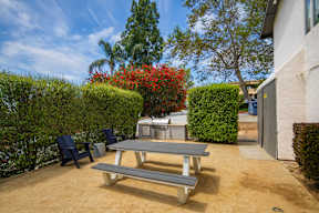 A backyard with a picnic table and chairs.