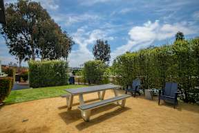 A picnic table and chairs are set up in a backyard.