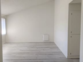 View of living room and hallway to bedrooms showing easy care wood style flooring at the Steckel Apartments in Santa Paula, California.