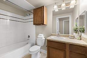 A white toilet sits next to a white sink in a bathroom.