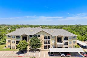 A large building with a parking lot in front.