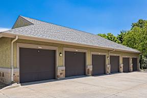 A building with a grey roof and four garage doors.