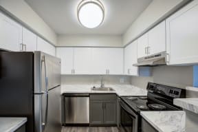 a kitchen with white cabinets and stainless steel appliances and a sink
