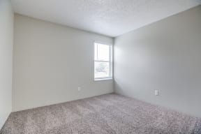 an empty room with carpet and a window
