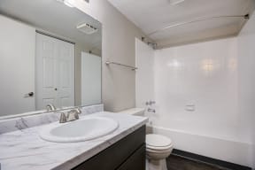 a bathroom with a sink toilet and shower and a mirror