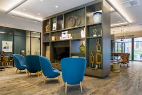 a lobby with blue chairs and a large display case in the background