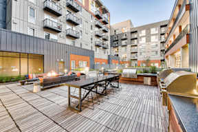 an outdoor patio with a table and chairs in an apartment building