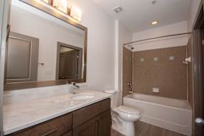A bathroom with a white sink and a white toilet.