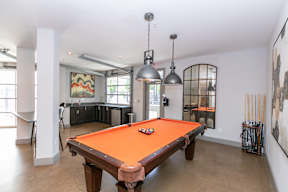 A pool table is in the middle of the room.