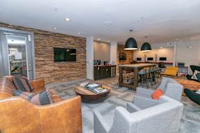 A modern living room with a stone wall and a flat screen TV.