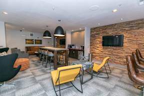 A modern living room with a stone wall and a flat screen TV.