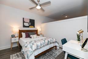 A bedroom with a bed, desk, and chair.