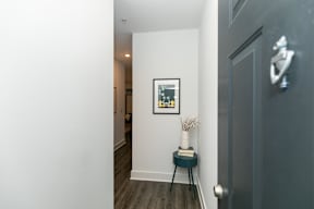A hallway with a grey door and a picture on the wall.
