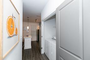 A hallway with a washer and dryer in the background.
