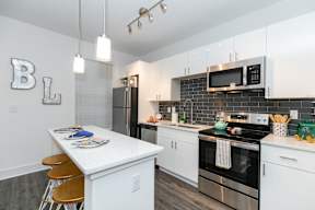 A modern kitchen with white cabinets and a large island.