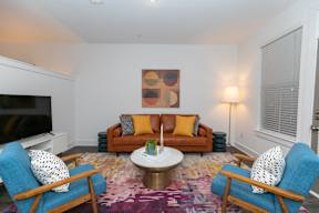 A living room with a brown couch and blue chairs.