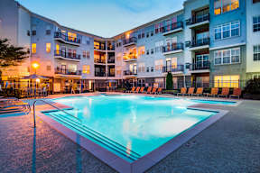 A large swimming pool in front of apartment buildings.