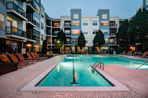 A swimming pool in a residential area surrounded by apartment buildings.