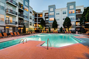 A large swimming pool in front of apartment buildings.