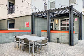 A patio with a table and chairs under a pergola.