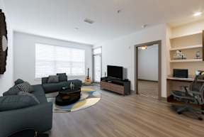 A modern living room with a grey sofa, a coffee table, a television, and a guitar.