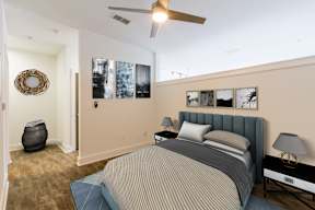 A bedroom with a bed, nightstand, and pictures on the wall.
