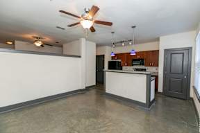 A kitchen with a white counter and a ceiling fan.