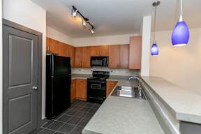 A kitchen with black appliances and wooden cabinets.