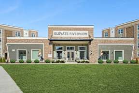 The front of a building named Elevate Riverview with a green lawn in front.