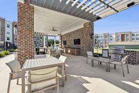 A patio with a table and chairs under a roof.