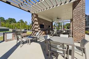 A patio with a table and chairs under a roof.