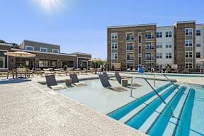 A sunny day at the pool with chairs and umbrellas.