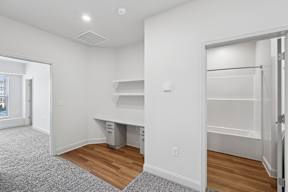 A white room with a desk and drawers.