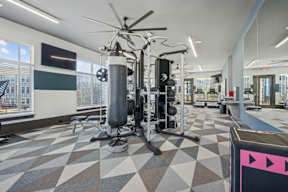 A gym with a variety of equipment including a treadmill, a stationary bike, and a rowing machine.