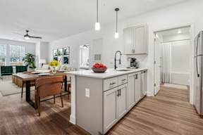 A kitchen with a table and chairs in front of it.