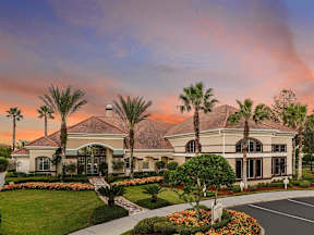 Exterior of the clubhouse with sidewalks and palm trees