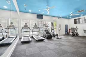 A gym with treadmills, elliptical machines, and other exercise equipment.