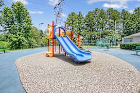 A playground with a blue slide and a red and yellow structure.