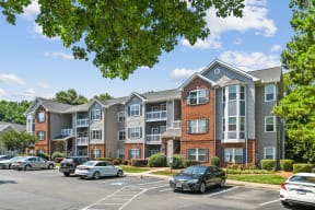 an apartment building with cars parked in a parking lot