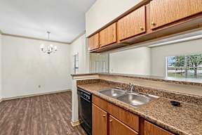 A kitchen with brown cabinets and a granite countertop.