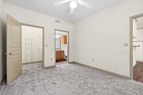 A room with a ceiling fan and a carpeted floor.