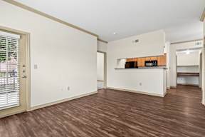 A room with a brown floor and white walls.