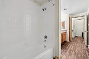 A white bathroom with a white tub and a white door.
