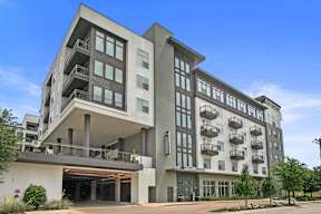 a large apartment building with balconies and a sky background