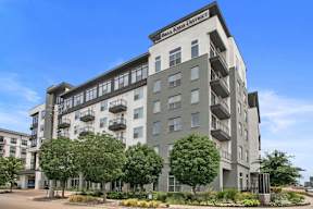 a large apartment building with trees in front of it