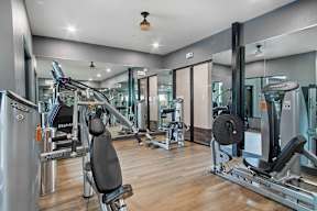 a gym with cardio equipment and glass walls