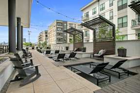 an outdoor patio with chairs and tables and buildings in the background