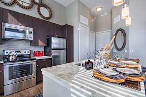 a kitchen with stainless steel appliances and a marble counter top