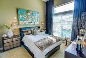 a bedroom with a bed and a large window